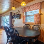 Image showing the dining room table and chairs in island cabin. Living room in slightly seen in the back.