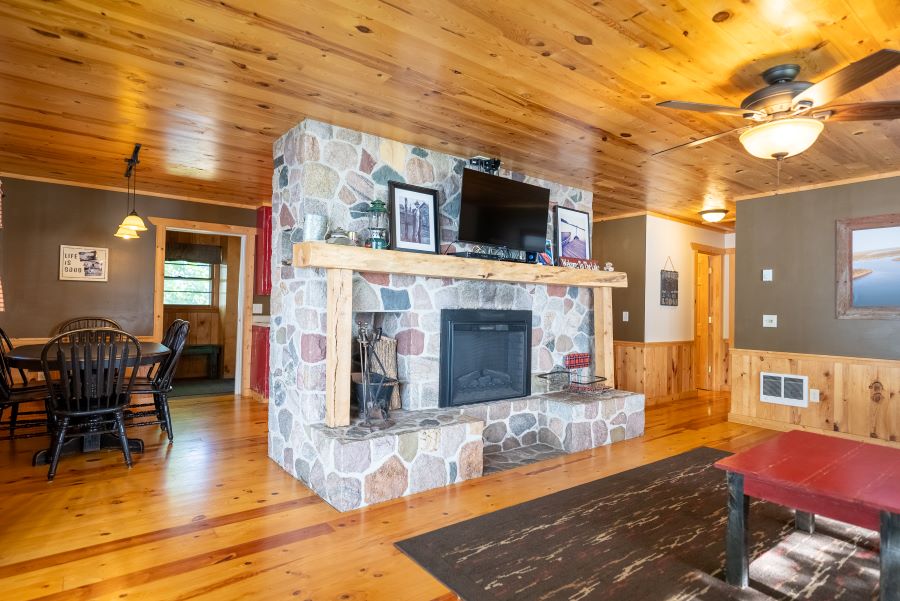 View of the living room fireplace on the island cabin. Shows fireplace and TV mounted on the wall.